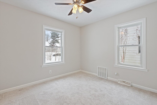 spare room with ceiling fan and light carpet