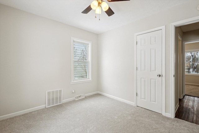 unfurnished bedroom with carpet floors, ceiling fan, and multiple windows