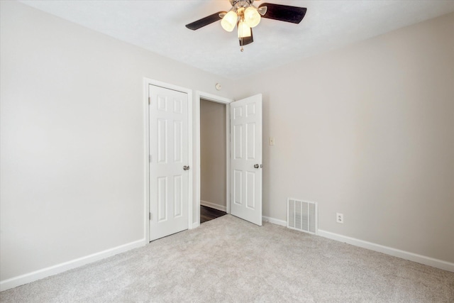 unfurnished bedroom featuring light colored carpet and ceiling fan