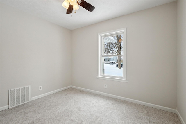 spare room featuring ceiling fan, light carpet, and a wealth of natural light