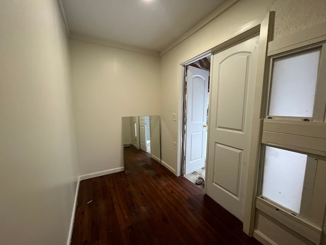 corridor with dark hardwood / wood-style flooring and crown molding