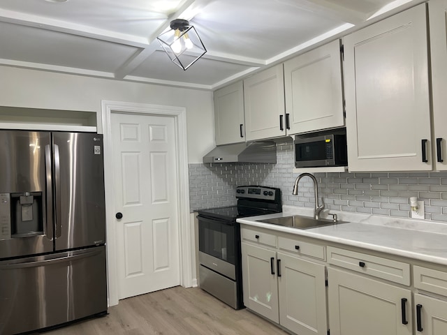 kitchen featuring stainless steel appliances, decorative backsplash, light hardwood / wood-style flooring, and sink