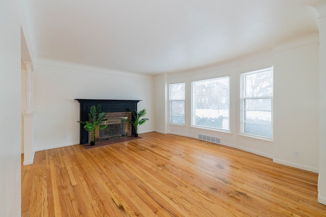 unfurnished living room with crown molding and light hardwood / wood-style flooring