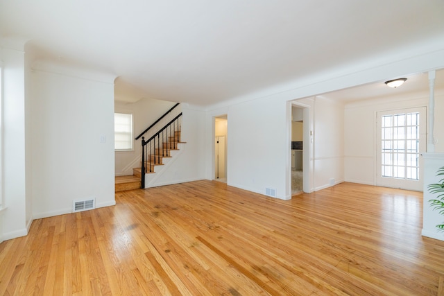 unfurnished living room featuring light wood-type flooring and a wealth of natural light