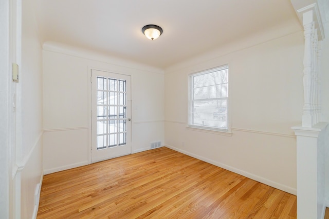 empty room featuring hardwood / wood-style floors and crown molding