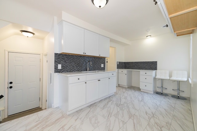 kitchen featuring white cabinets, tasteful backsplash, and sink