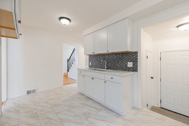 kitchen with sink, white cabinets, and decorative backsplash