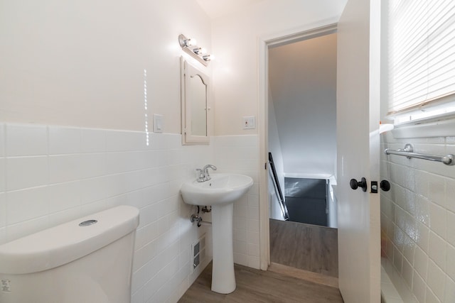 bathroom with toilet, tile walls, sink, and hardwood / wood-style flooring