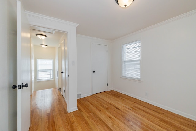 unfurnished bedroom with a closet, light wood-type flooring, and crown molding