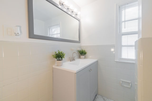 bathroom with vanity, tile walls, and a healthy amount of sunlight