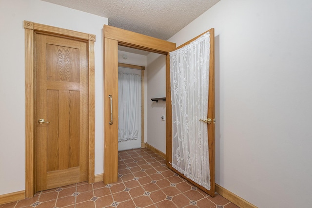 hallway with a textured ceiling