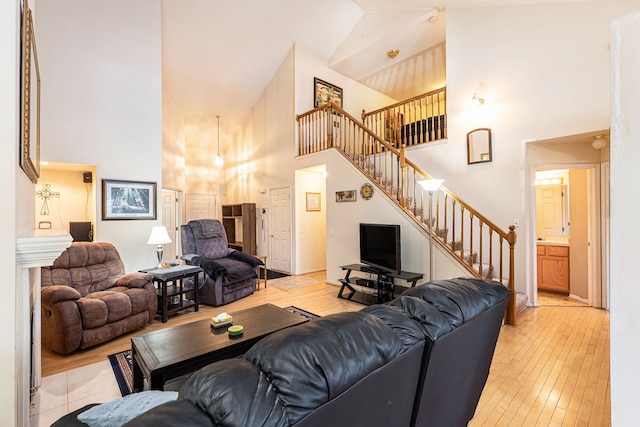 living room featuring high vaulted ceiling and light hardwood / wood-style floors