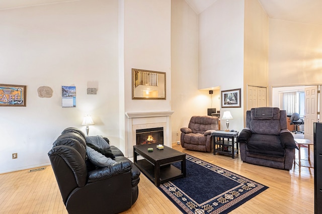 living room with a high ceiling and hardwood / wood-style flooring