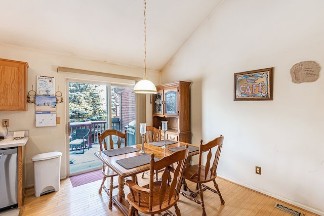 dining area with lofted ceiling and light wood-type flooring