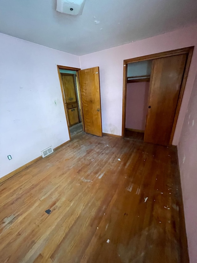 unfurnished bedroom with hardwood / wood-style floors and a closet