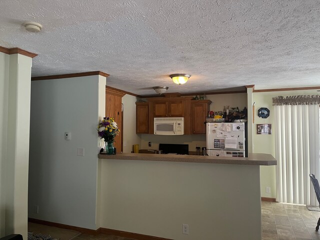 kitchen featuring kitchen peninsula, white appliances, and ornamental molding