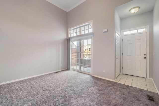 carpeted entrance foyer featuring a high ceiling