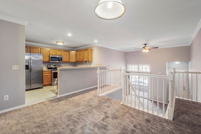 kitchen with stainless steel appliances, light colored carpet, and ornamental molding