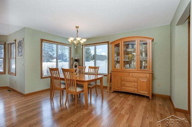 dining room with a notable chandelier and light hardwood / wood-style flooring