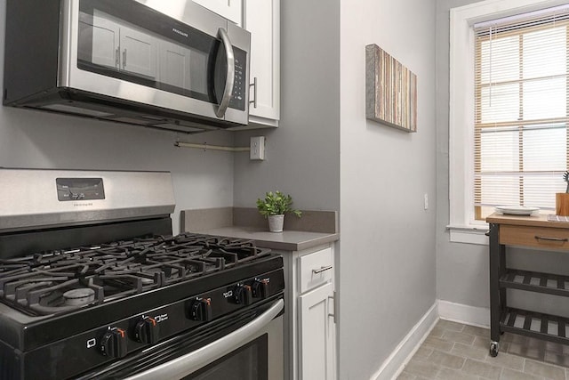 kitchen featuring white cabinets, light tile patterned floors, and appliances with stainless steel finishes