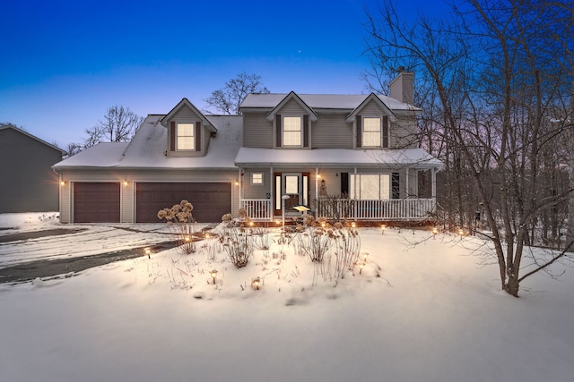 new england style home featuring covered porch and a garage