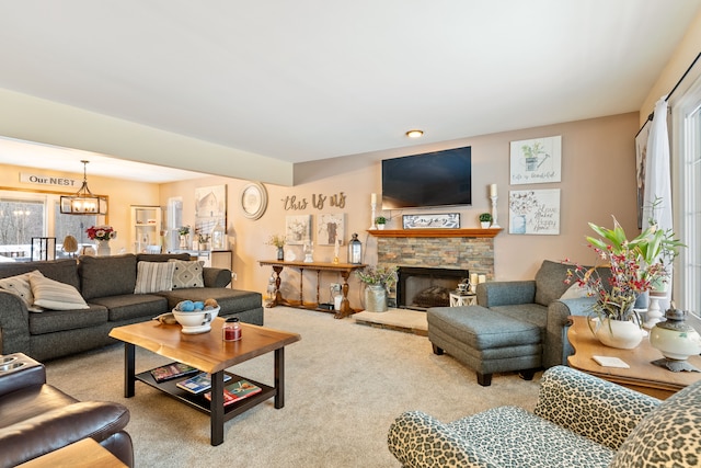 living room featuring carpet, a fireplace, and a notable chandelier