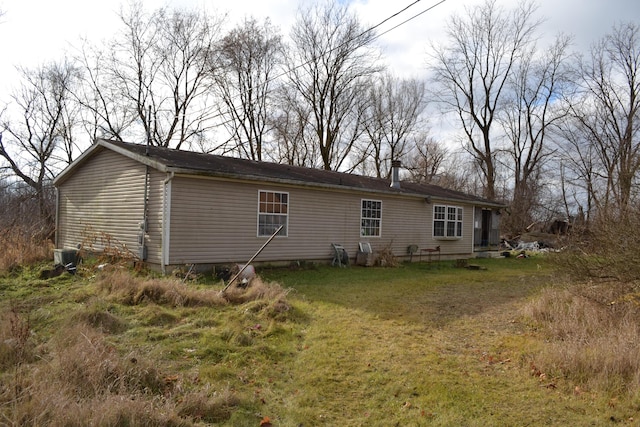 rear view of property featuring a lawn