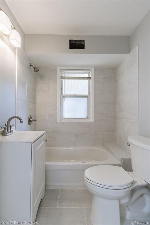 full bathroom featuring tiled shower / bath combo, vanity, and toilet