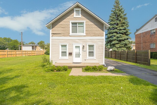 rear view of house featuring a yard