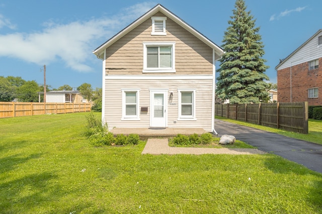 rear view of house featuring a yard