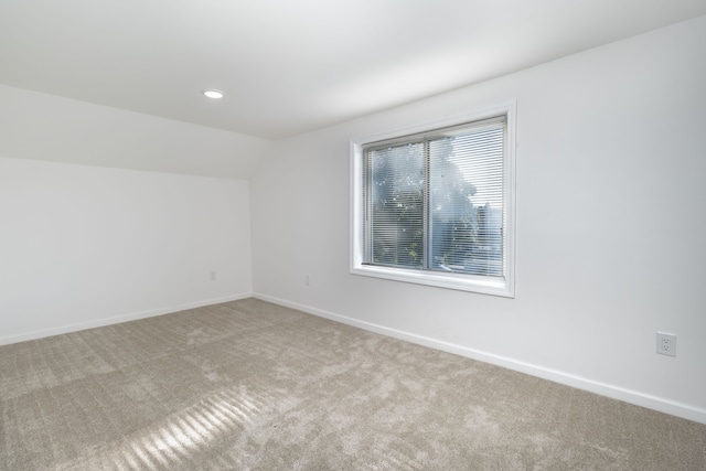 additional living space with light carpet and lofted ceiling