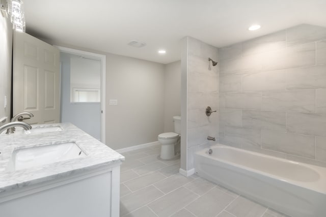 full bathroom featuring tiled shower / bath, vanity, toilet, and tile patterned flooring