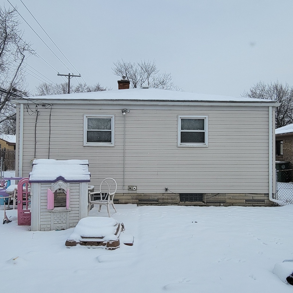 view of snow covered back of property