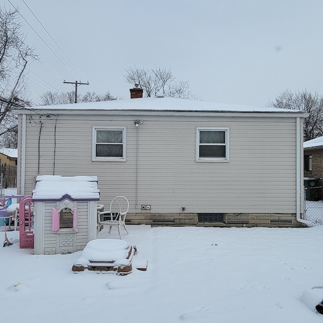 view of snow covered back of property