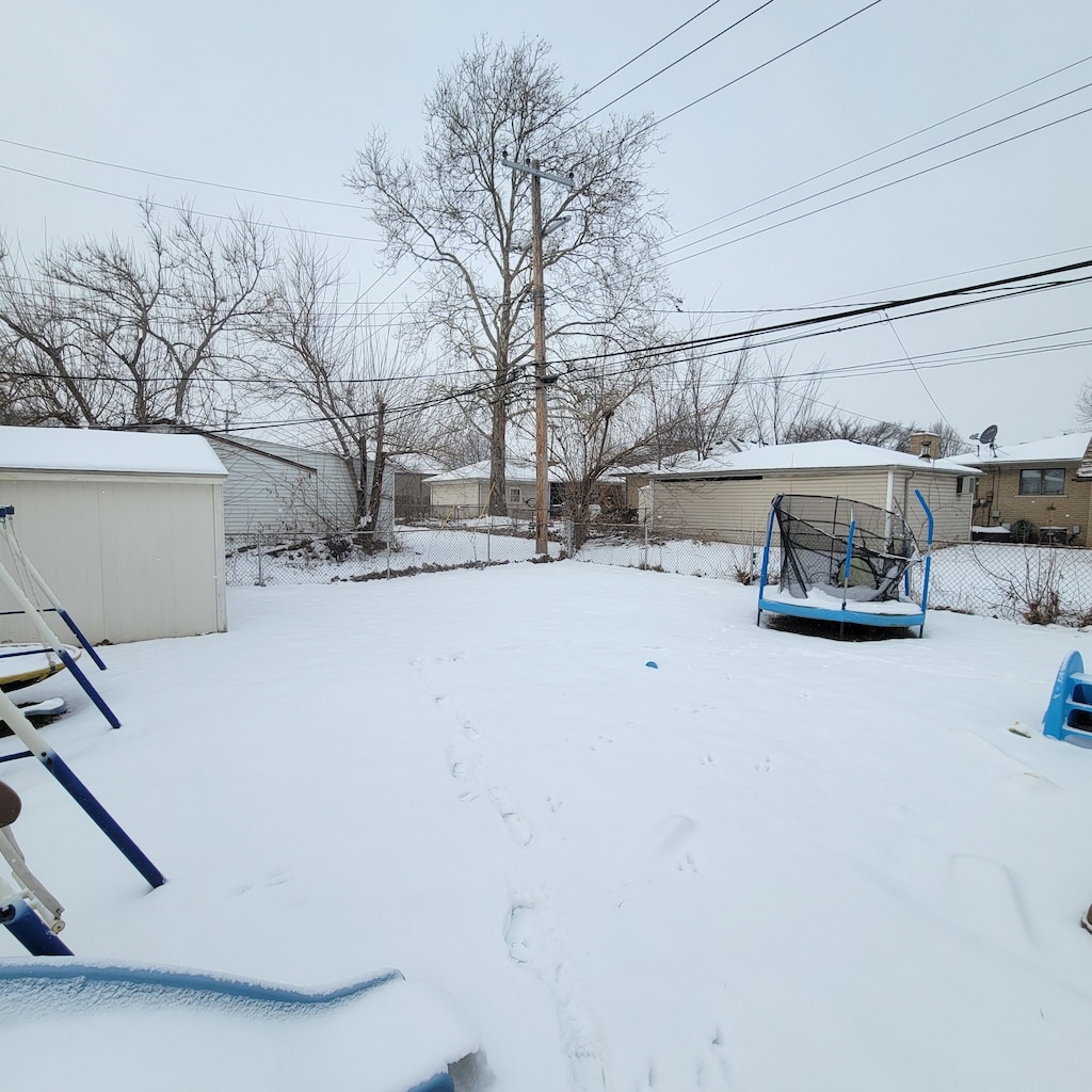 snowy yard featuring a trampoline