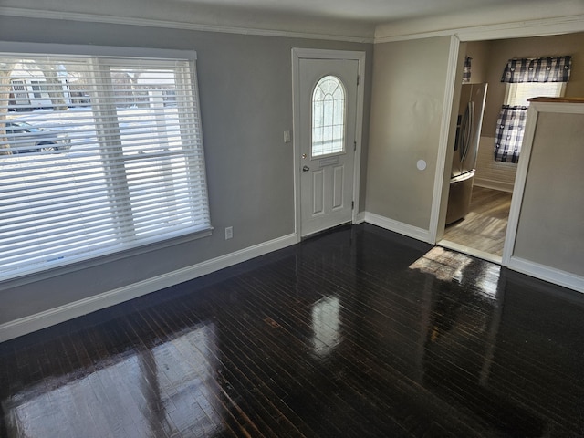 foyer entrance with dark hardwood / wood-style floors, ornamental molding, and a healthy amount of sunlight