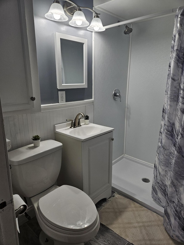 bathroom featuring toilet, vanity, and a shower with curtain