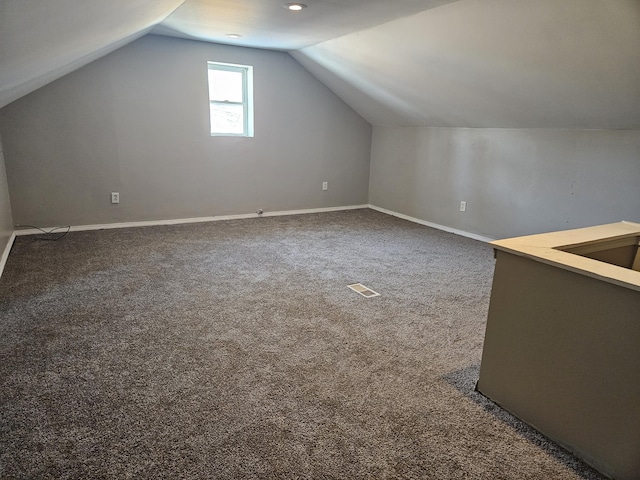 bonus room with vaulted ceiling and carpet floors