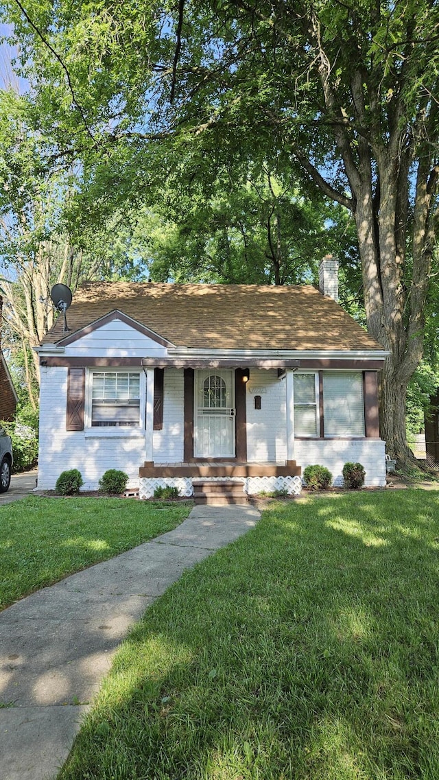 17737 Lenore Ave, Detroit, MI 48219 - single story home featuring a chimney, brick siding, a front yard, and a shingled roof
