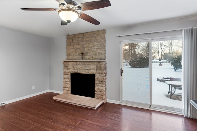 unfurnished living room featuring ceiling fan, dark wood-type flooring, and a fireplace