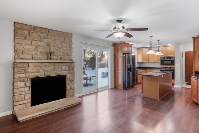 kitchen featuring black appliances, ceiling fan, dark hardwood / wood-style floors, a kitchen island, and decorative light fixtures