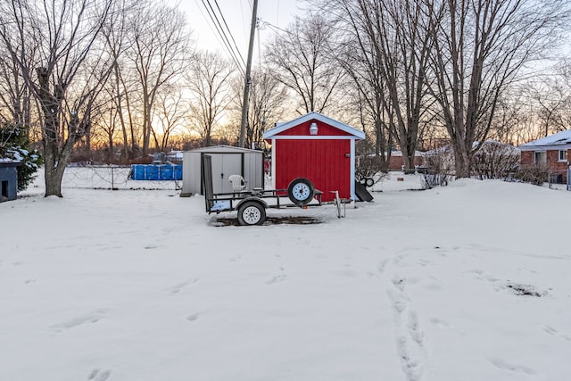 yard covered in snow featuring a shed