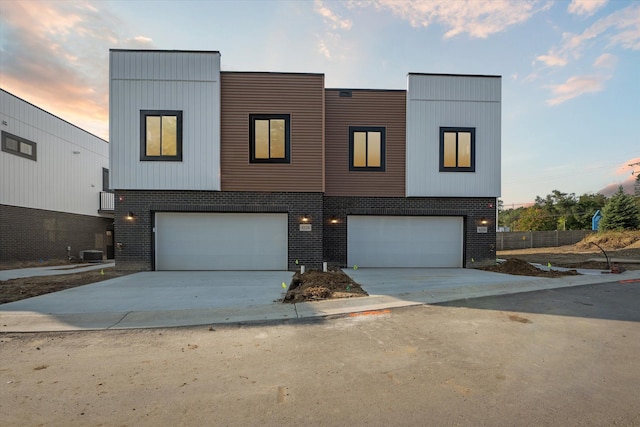 contemporary house featuring a garage and central AC unit