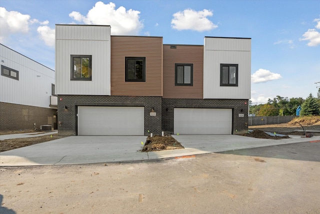 view of front of home with a garage and central air condition unit