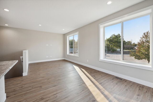 unfurnished living room with hardwood / wood-style floors and a healthy amount of sunlight