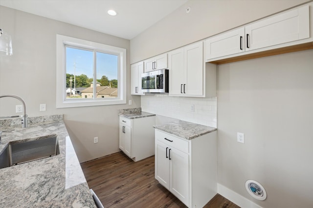 kitchen featuring white cabinets, tasteful backsplash, sink, dark hardwood / wood-style floors, and light stone counters