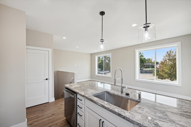 kitchen with white cabinetry, decorative light fixtures, stainless steel dishwasher, light stone counters, and sink