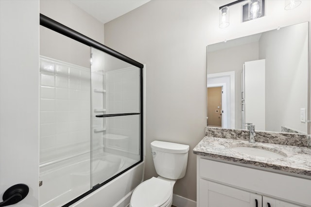 full bathroom featuring toilet, bath / shower combo with glass door, and vanity