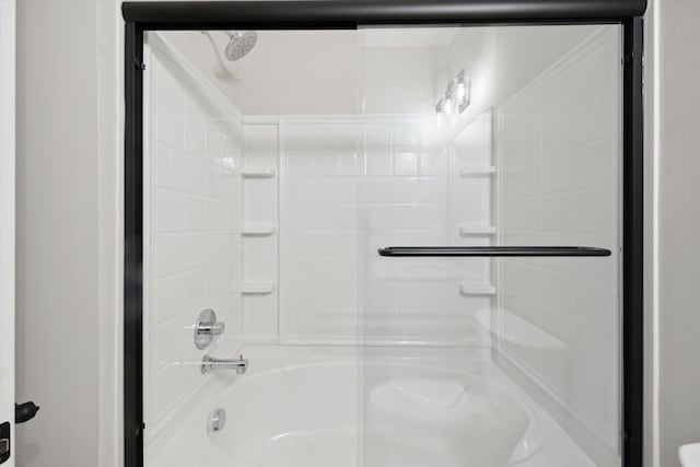 bathroom with bath / shower combo with glass door