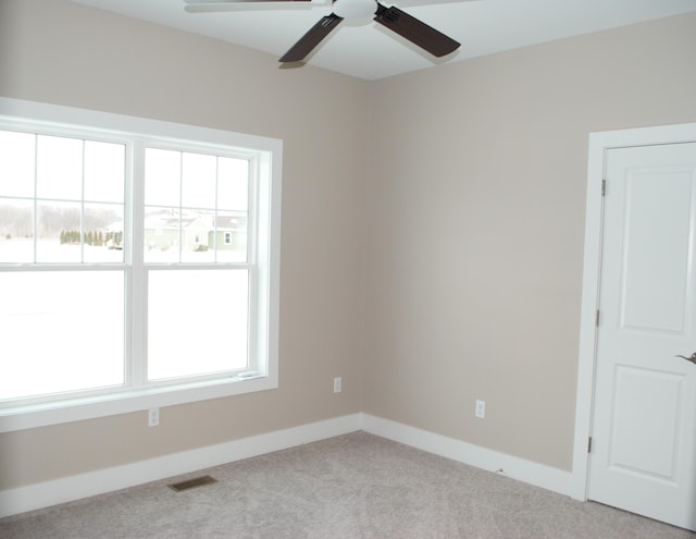 carpeted empty room featuring ceiling fan